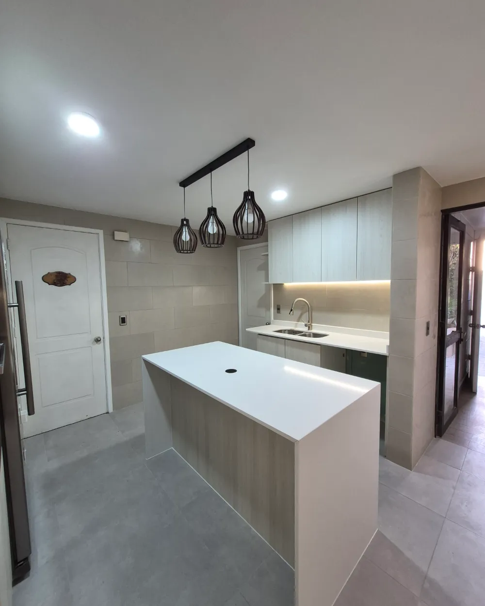 Cocina con isla y luces colgantes realizada por Deco Antonella